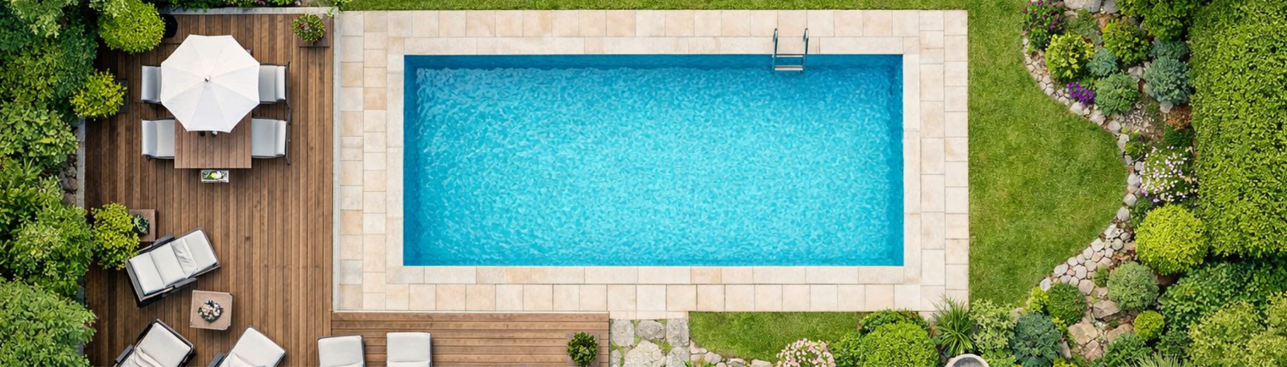 Topshots einer Fotografie von einem Pool mit Terrasse, Sonnenschirm und Liegen. Rechts befinden sich Grünflächen.